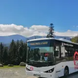 Biały autobus "Karpacz Bus" z napisem "Komunikacja Miejska" na tle gór i lasu. Zastanawiasz się, ile kosztuje autobus?