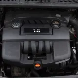 Silnik Volkswagena 1.6 MPI, czarny, z logo marki i oznaczeniem pojemności.