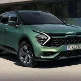 Nowy zielony Kia Sportage 1.6 benzyna prezentuje się nowocześnie przed budynkiem.