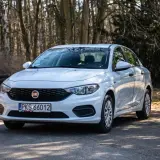 Biały Fiat Tipo 1.4 zaparkowany na leśnej drodze.
