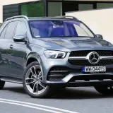 Szary Mercedes GLE 300d z eleganckimi felgami stoi przed nowoczesnym budynkiem.