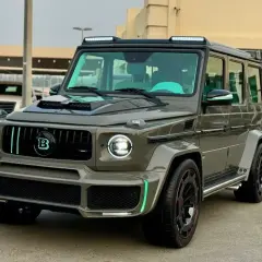 Szary Mercedes Brabus z neonowo-zielonymi akcentami i podświetlanym logo "B" na grillu.