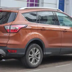 Pomarańczowy Ford Kuga 2.0 TDCI zaparkowany przy ulicy.