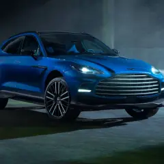 Niebieski Aston Martin DBX 707 lśni w półmroku, gotowy do podboju każdej drogi.