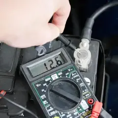 Sprawdzanie akumulatora miernikiem. Wynik 12.6V wskazuje na dobry stan baterii.