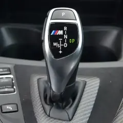 Oznaczenia automatycznej skrzyni biegów BMW M: P, R, N, D, M/S. Wskazują tryby jazdy i pozycje.