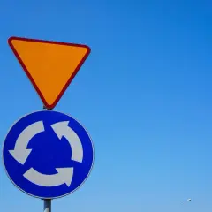 Znak drogowy "ustąp pierwszeństwa" nad znakiem "ruch okrężny". Uważaj, by nie spowodować wymuszenia pierwszeństwa na rondzie.