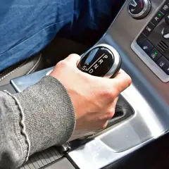 Dłoń na dźwigni zmiany biegów w samochodzie z automatyczną skrzynią. Proste wskazówki, jak jeździć automatem.