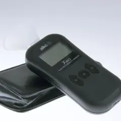 Czarny alkomat z wyświetlaczem i ustnikiem, obok etui.