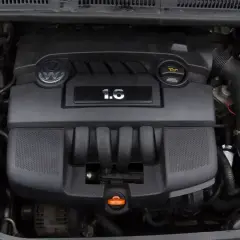 Silnik Volkswagena 1.6 MPI, czarny, z logo marki i oznaczeniem pojemności.