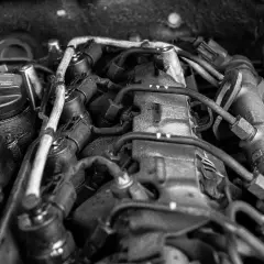 Widok silnika samochodowego. Na korku widać napis "To avoid damage to engine oil must not exceed max", sugerujący, że jest za dużo oleju w silniku.