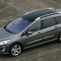 Szary Peugeot 308 1.6 HDi kombi z panoramicznym dachem stoi na betonowej nawierzchni.