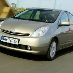 Złoty Toyota Prius 2 jedzie po moście.