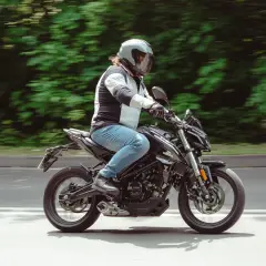 Mężczyzna w kasku jedzie czarnym motocyklem. Idealny motor na kat B, by poczuć wolność na drodze.