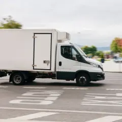 Biała chłodnia c1 pędzi ulicą, dostarczając świeże produkty.