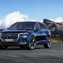 Błękitne Audi Q7 na tle górskiego krajobrazu. Poznaj jego imponujące audi q7 wymiary i możliwości terenowe.