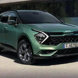 Nowy zielony Kia Sportage 1.6 benzyna prezentuje się nowocześnie przed budynkiem.