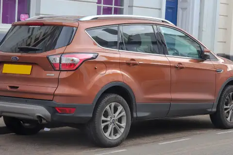 Pomarańczowy Ford Kuga 2.0 TDCI zaparkowany przy ulicy.