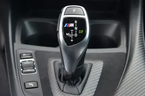 Oznaczenia automatycznej skrzyni biegów BMW M: P, R, N, D, M/S. Wskazują tryby jazdy i pozycje.