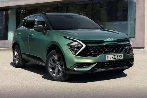 Nowy zielony Kia Sportage 1.6 benzyna prezentuje się nowocześnie przed budynkiem.