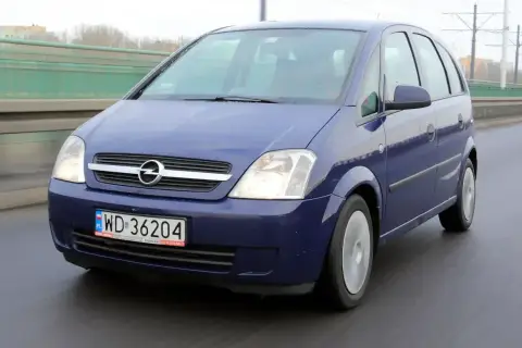 Niebieski Opel Meriva 1.6 benzyna jedzie po mokrej drodze.