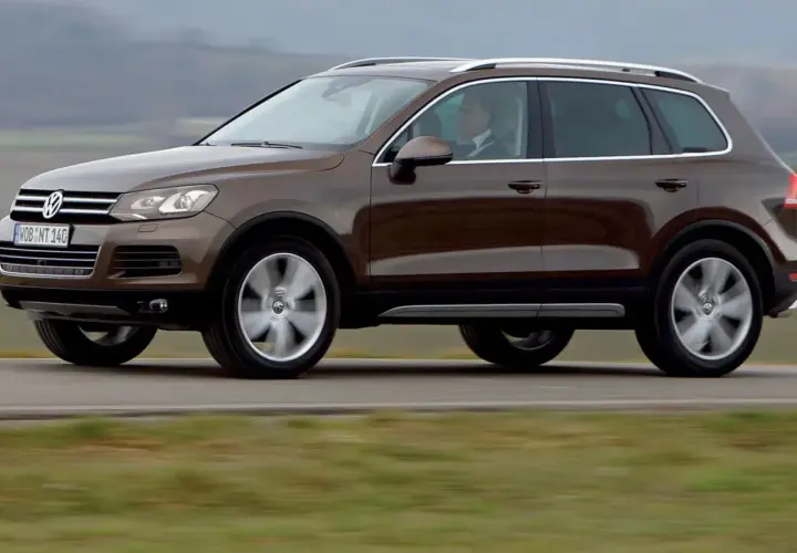 Brązowy Volkswagen Touareg w ruchu. Ten model to jeden z najmniej awaryjnych SUV-ów 10 letnich, idealny na długie podróże.