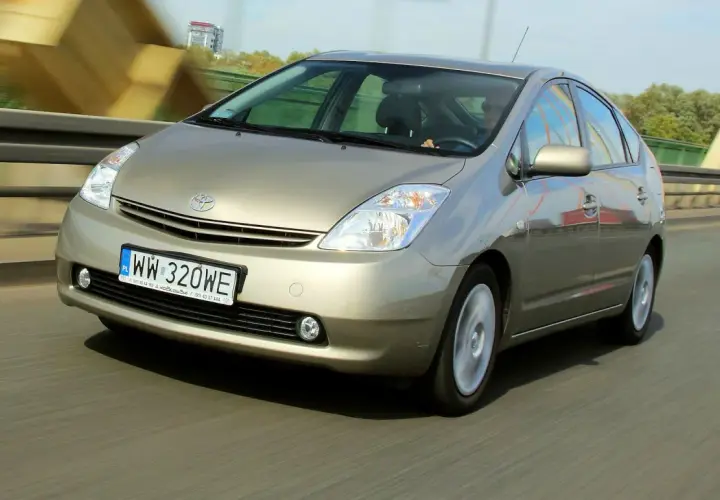 Złoty Toyota Prius 2 jedzie po moście.