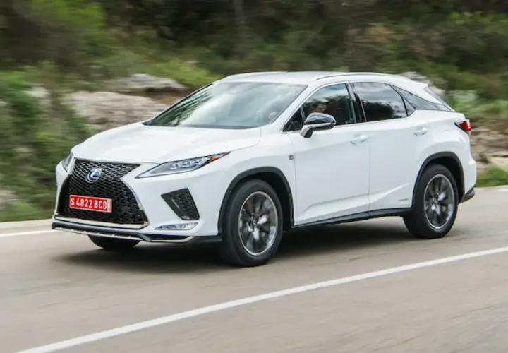 Biały Lexus RX 300 pędzi po krętej drodze wśród zielonych wzgórz.