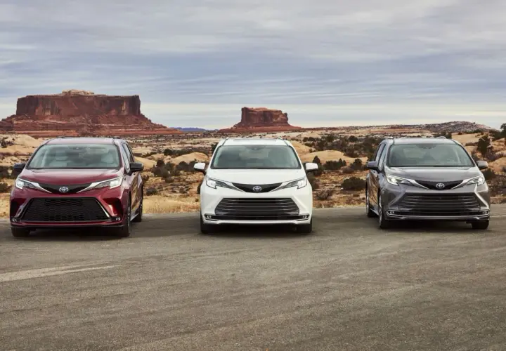 Trzy modele Toyota Sienna 2025 w różnych kolorach stoją na tle pustynnego krajobrazu z formacjami skalnymi.