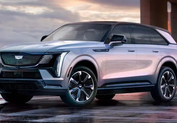 Elegancki Cadillac Escalade 2025 w kolorze srebrnym, z czarnym dachem i stylowymi felgami, prezentuje się imponująco na mokrej nawierzchni.