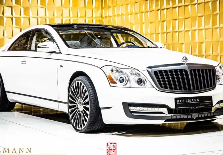 Biały Maybach 57 S z czarnym dachem i felgami, lśniącym na tle złotej, geometrycznej ściany.
