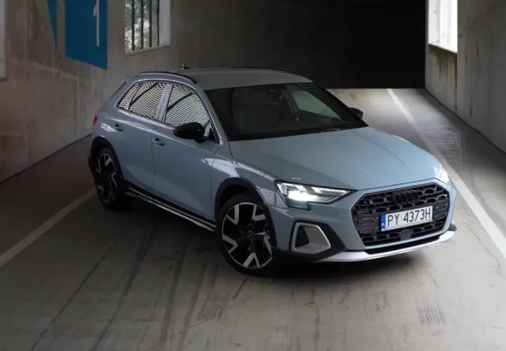 Jasnoszary Audi A1 Citycarver, uważany za najmniej awaryjne audi, stoi na betonowym parkingu.