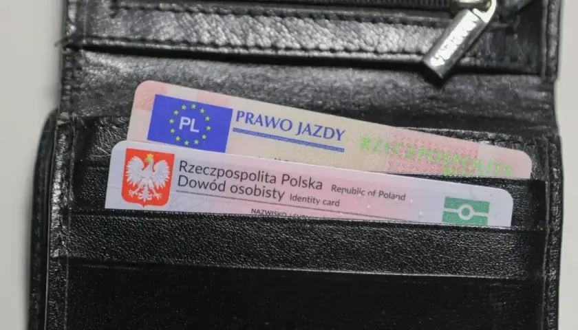 Czarny portfel z polskim dowodem osobistym i prawem jazdy. Na dokumencie prawa jazdy widnieje napis "PRAWO JAZDY", a na dowodzie "Rzeczpospolita Polska Dowód osobisty".