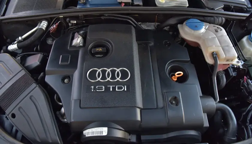 Silnik 1.9 TDI Audi z widocznym logo i oznaczeniem. Widać elementy układu chłodzenia i akumulator.