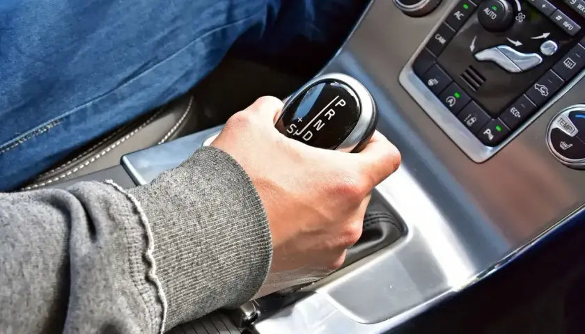 Dłoń na dźwigni zmiany biegów w samochodzie z automatyczną skrzynią. Proste wskazówki, jak jeździć automatem.