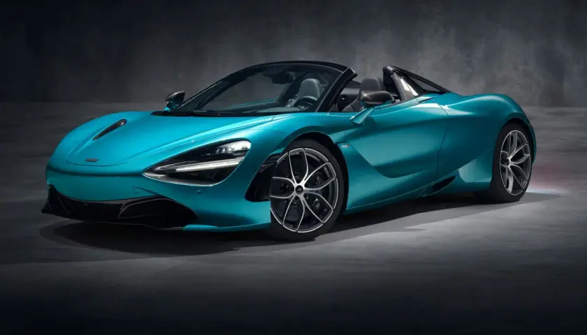 Turkusowy McLaren 720S Spider z otwartym dachem, gotowy do jazdy po torze.