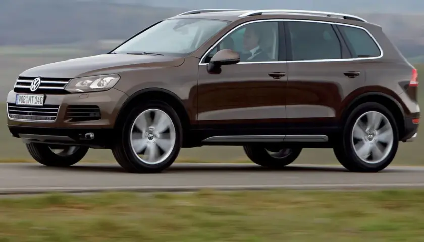 Brązowy Volkswagen Touareg w ruchu. Ten model to jeden z najmniej awaryjnych SUV-ów 10 letnich, idealny na długie podróże.