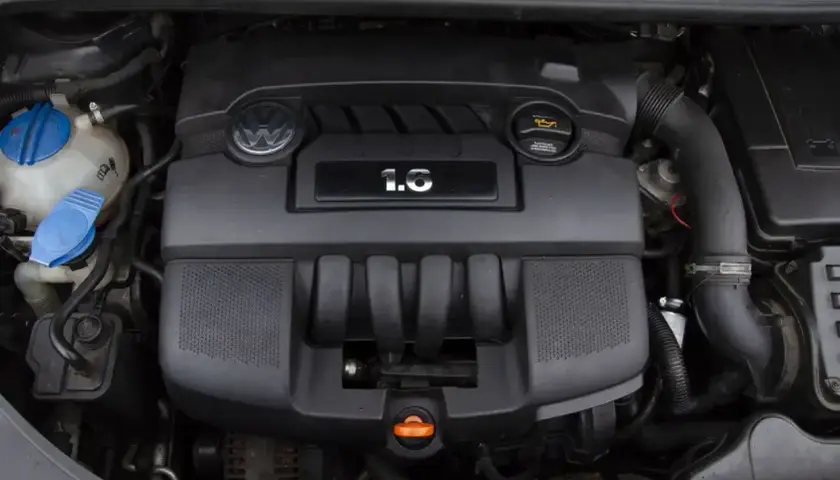 Silnik Volkswagena 1.6 MPI, czarny, z logo marki i oznaczeniem pojemności.