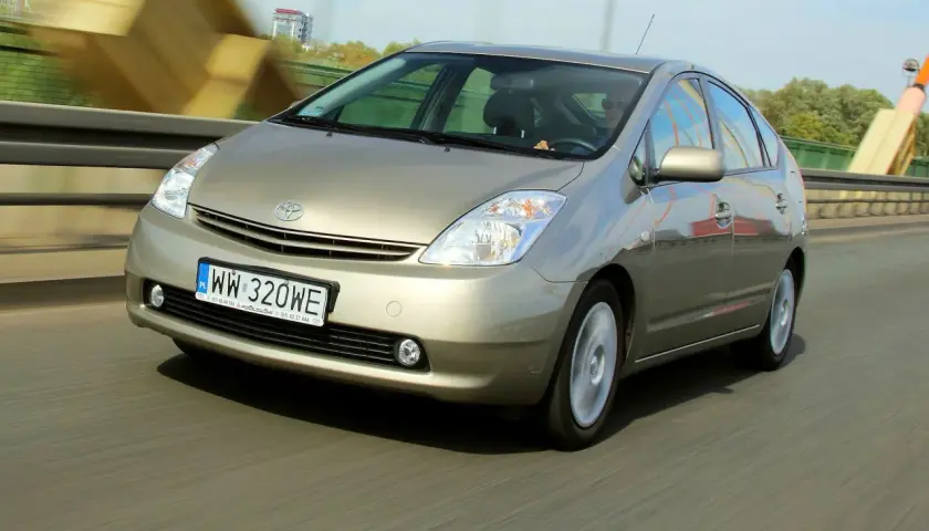 Złoty Toyota Prius 2 jedzie po moście.