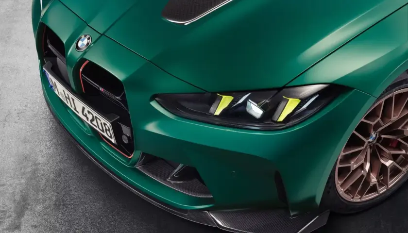 Przód zielonego BMW M4 CSL z detalami z włókna węglowego i złotymi felgami.