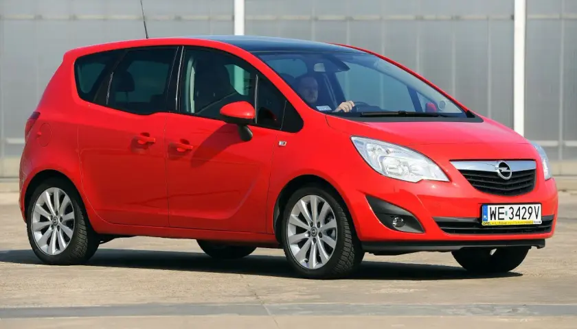 Czerwony Opel Meriva 1.7 CDTI z czarnym dachem, zaparkowany na zewnątrz.