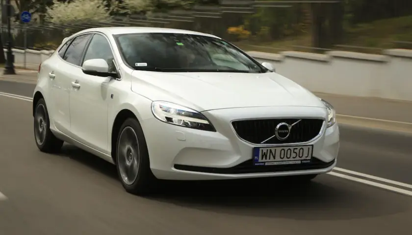 Białe Volvo V40 D2 w ruchu miejskim, z widocznym numerem rejestracyjnym WN 0050J.