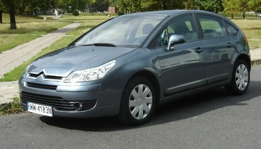 Szary Citroen C4 1.6 HDI zaparkowany na tle parku.