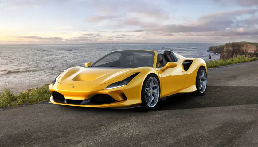 Żółte Ferrari F8 Spider na tle klifów i oceanu.