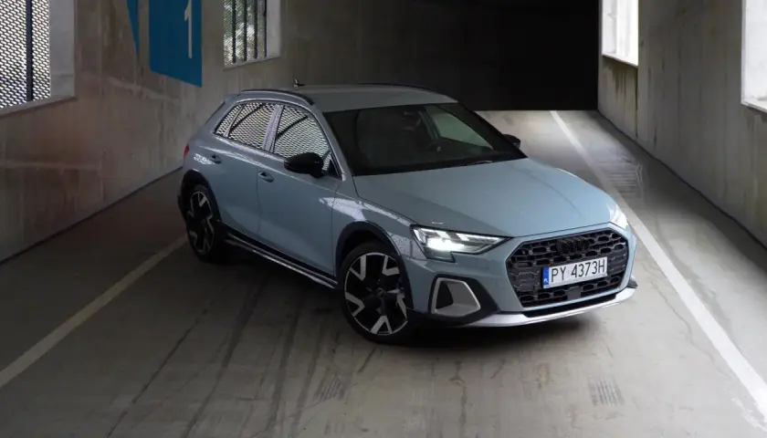 Jasnoszary Audi A1 Citycarver, uważany za najmniej awaryjne audi, stoi na betonowym parkingu.