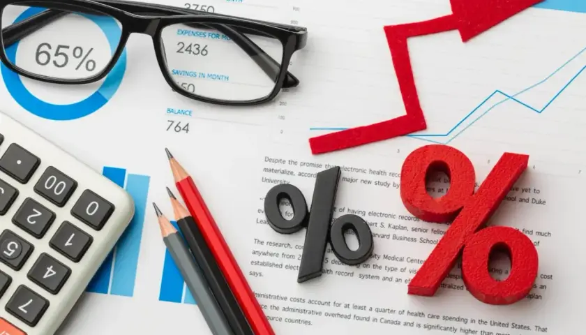 Kalkulator, okulary i wykresy sugerują analizę finansową, być może związaną z kredytem na samochód.