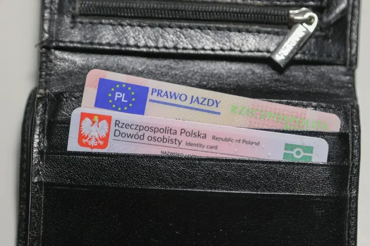 Czarny portfel z polskim dowodem osobistym i prawem jazdy. Na dokumencie prawa jazdy widnieje napis "PRAWO JAZDY", a na dowodzie "Rzeczpospolita Polska Dowód osobisty".