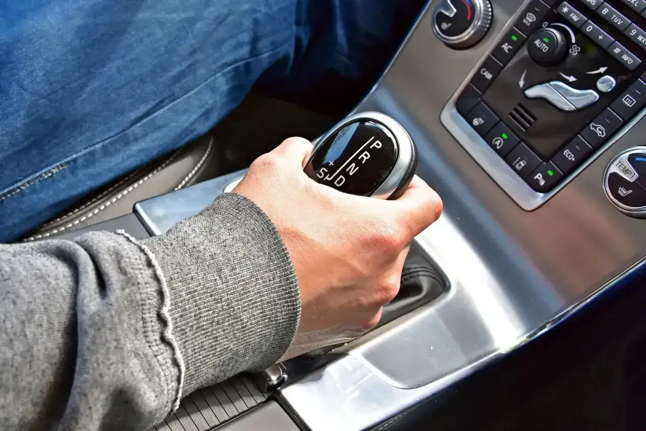 Dłoń na dźwigni zmiany biegów w samochodzie z automatyczną skrzynią. Proste wskazówki, jak jeździć automatem.