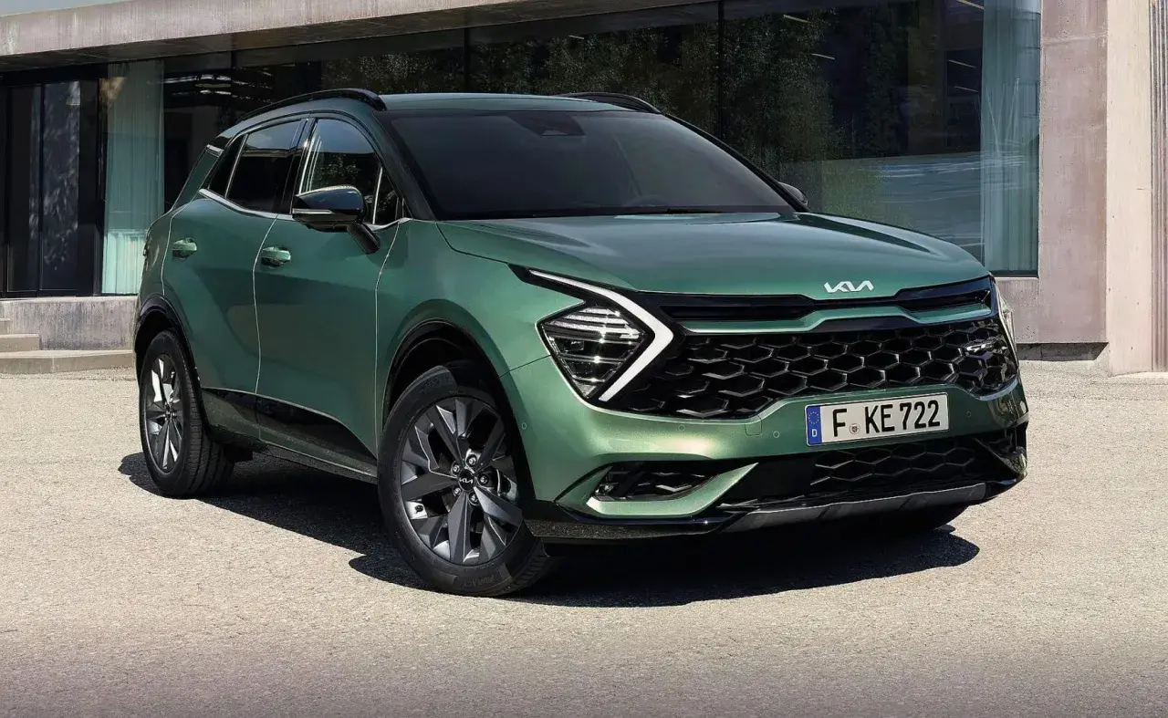 Nowy zielony Kia Sportage 1.6 benzyna prezentuje się nowocześnie przed budynkiem.