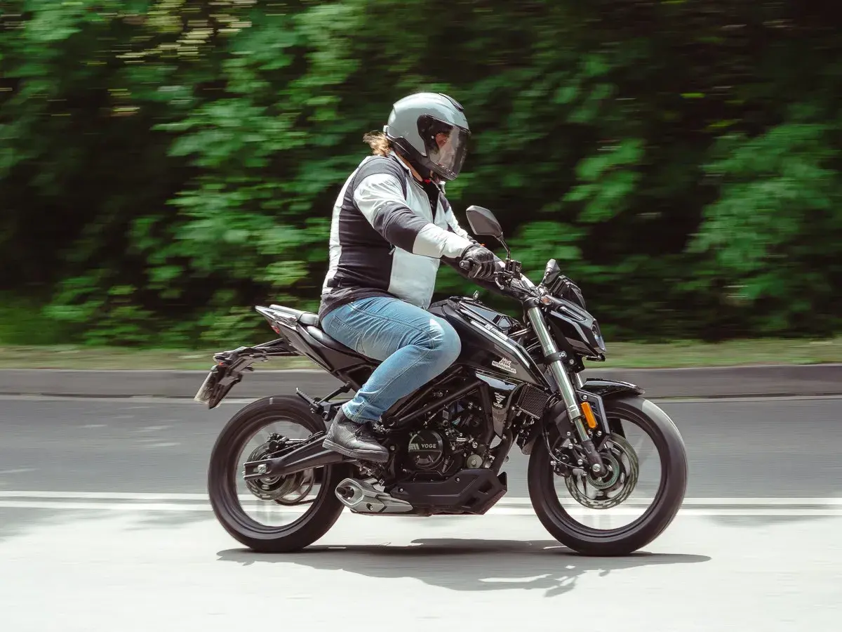 Mężczyzna w kasku jedzie czarnym motocyklem. Idealny motor na kat B, by poczuć wolność na drodze.
